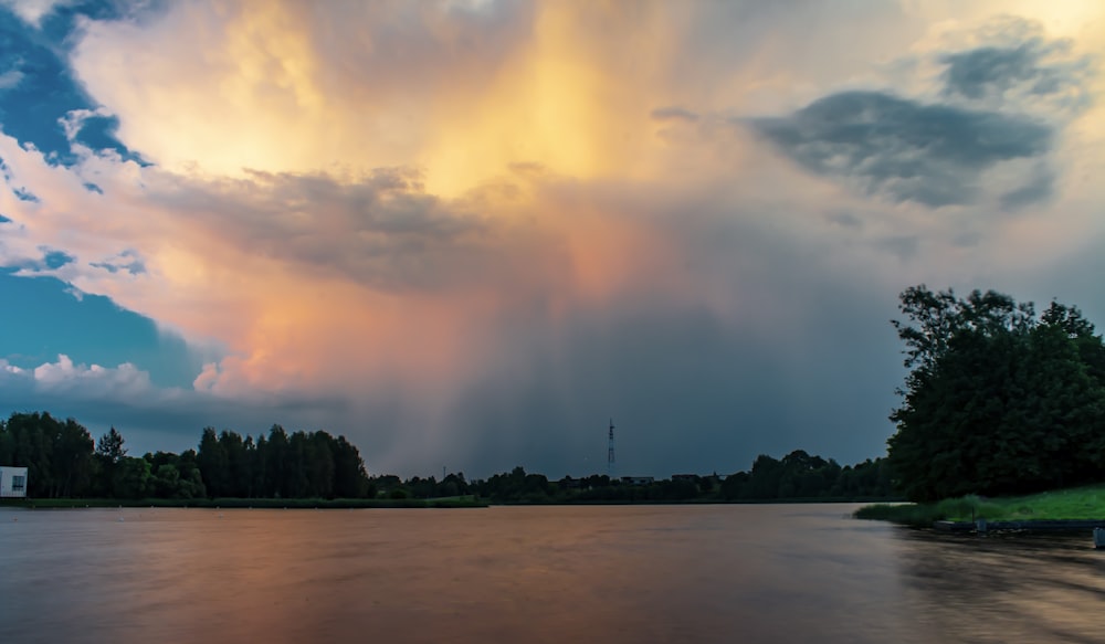 a large cloud looms over a body of water