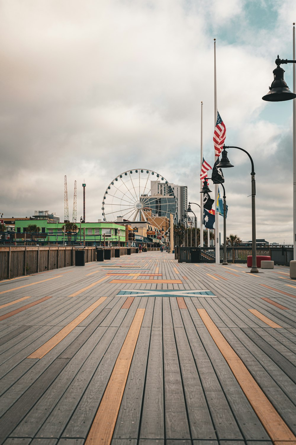 a boardwalk with a ferris wheel in the background
