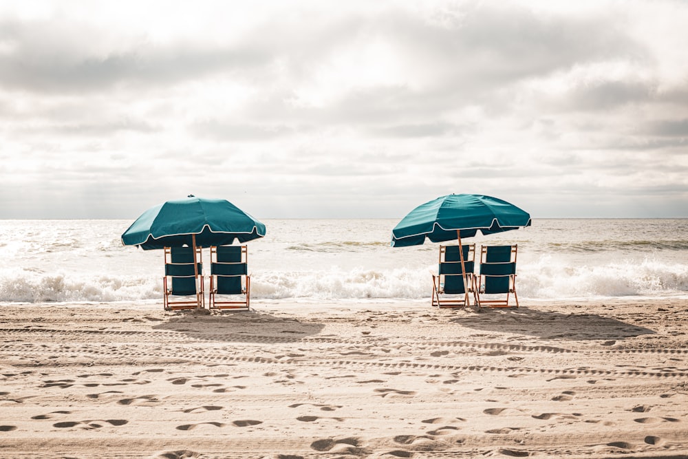 two lawn chairs with umbrellas on a beach