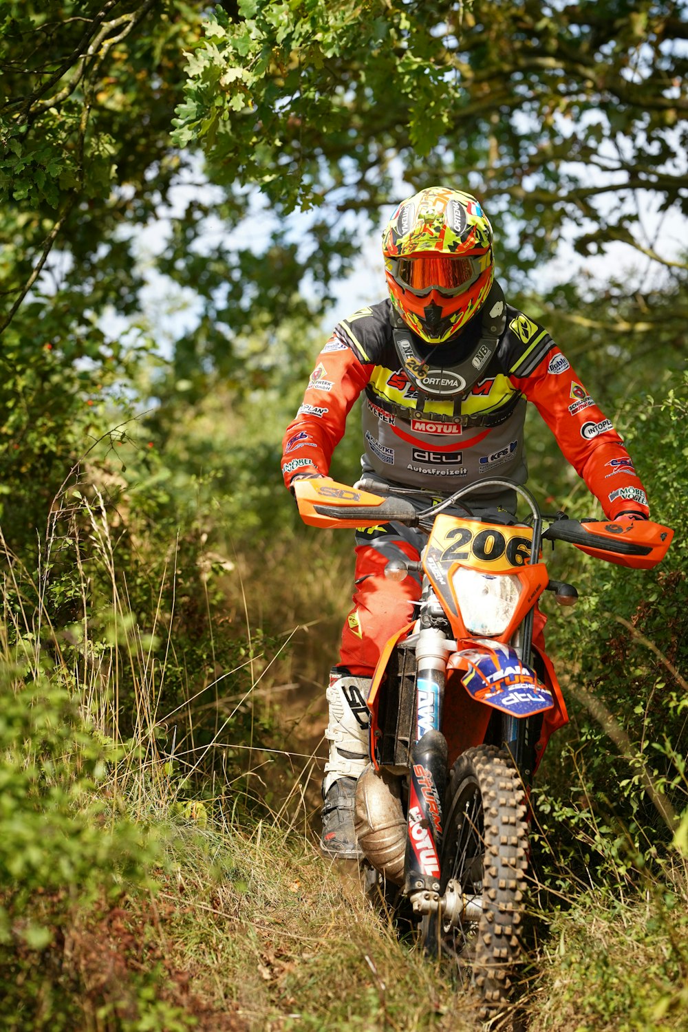 a man riding a dirt bike through a forest