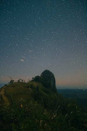 A vibrant starry sky over a calm landscape.