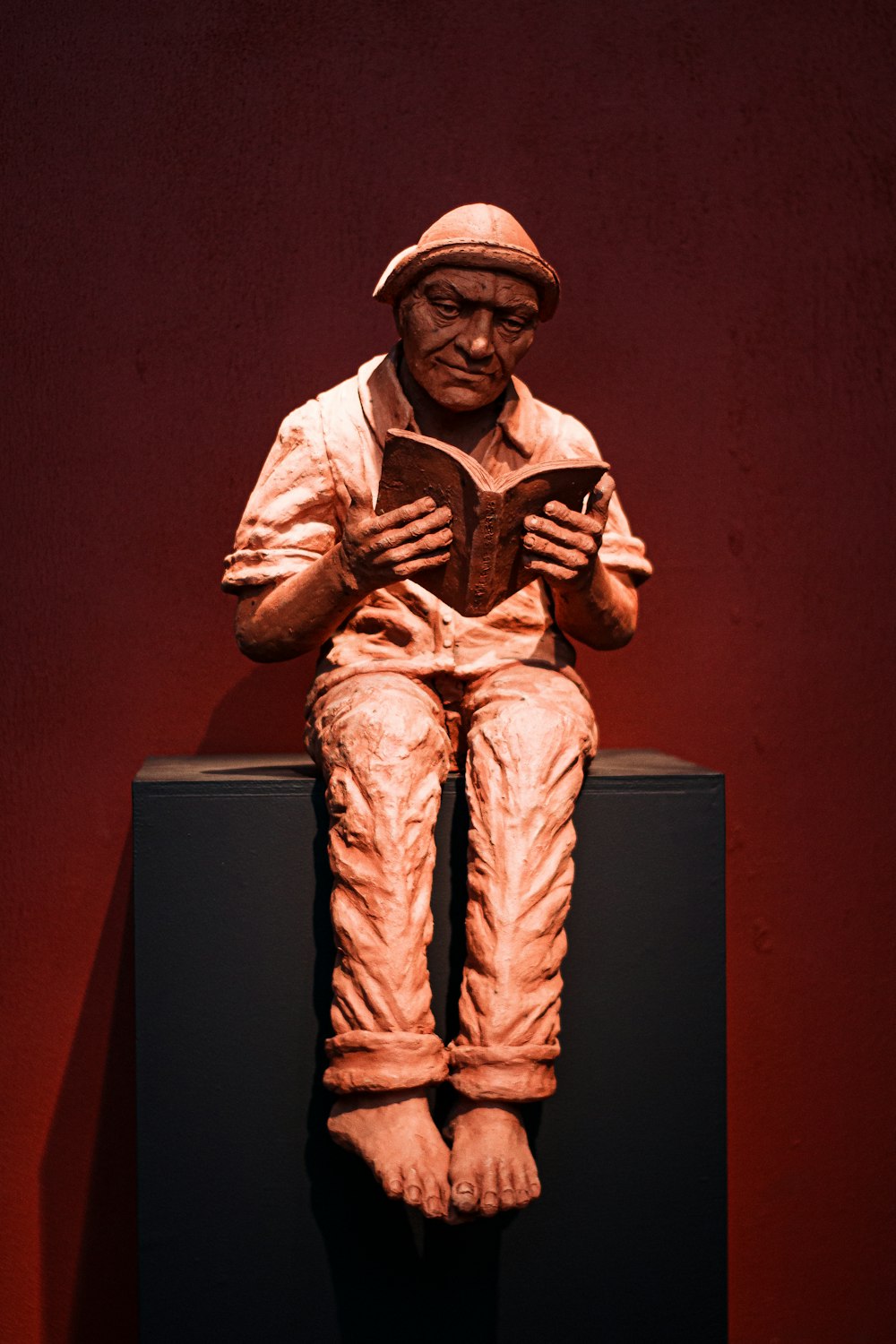 a statue of a man reading a book