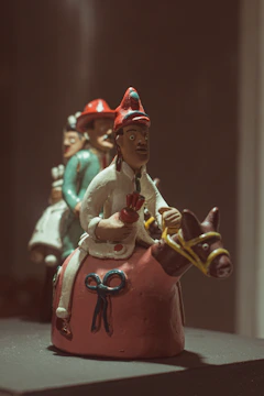 Traditional clay sculpture of a man wearing a hat and carrying a bag, symbolizing local heritage.