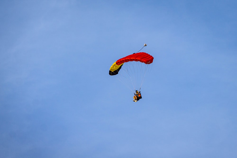 two people are parasailing in the blue sky
