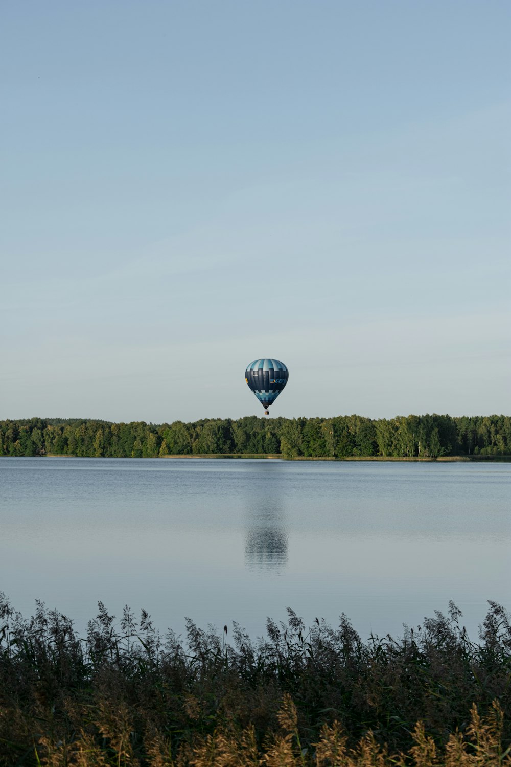 a hot air balloon flying over a lake