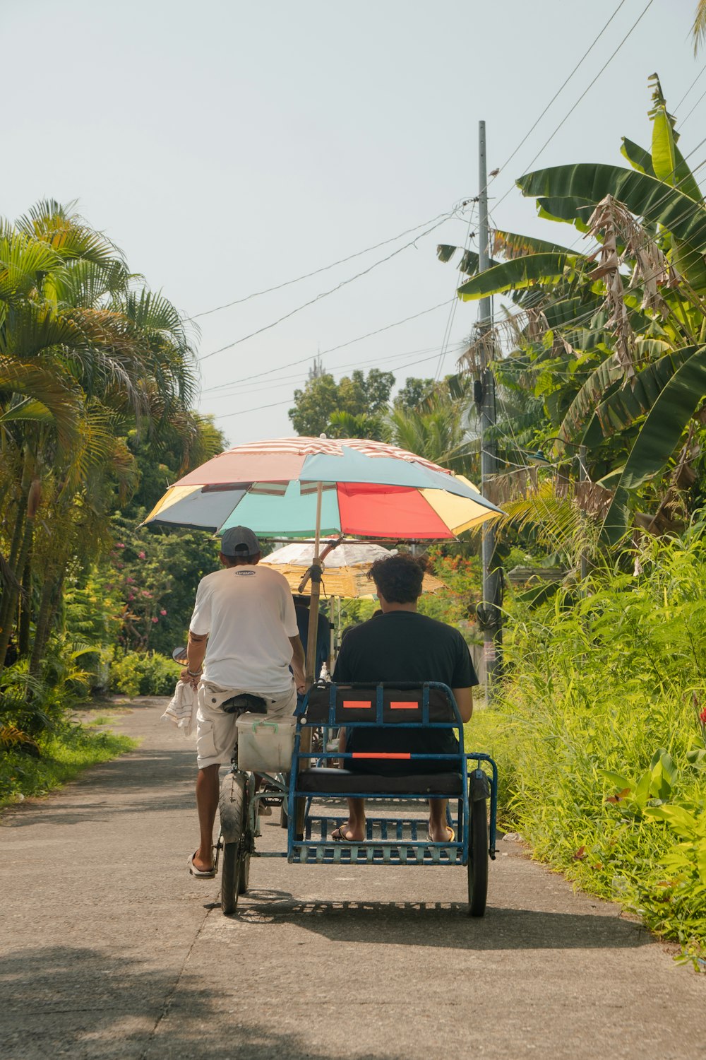 a man and a woman riding a bike with an umbrella