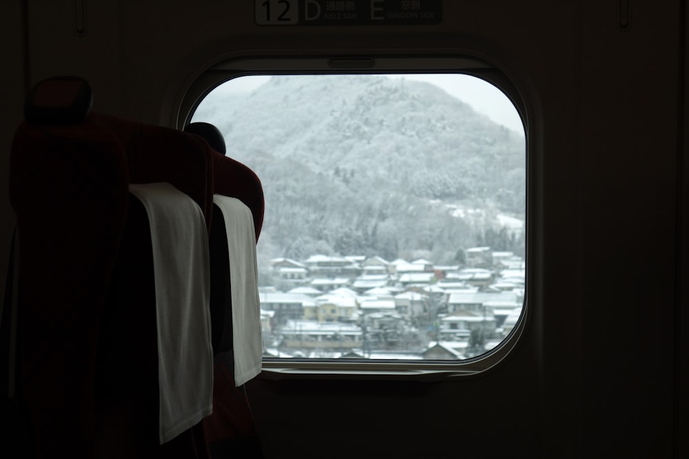 ein Fenster mit Blick auf einen verschneiten Berg