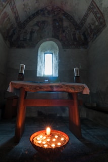 A peaceful chapel interior with soft morning light illuminating a wooden altar adorned with candles and a Bible.