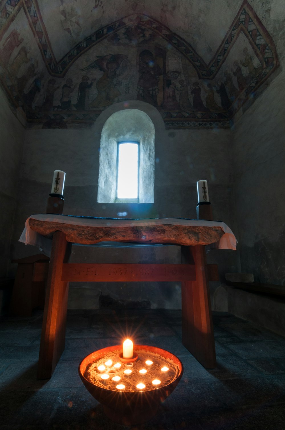 a lit candle sitting on top of a wooden table