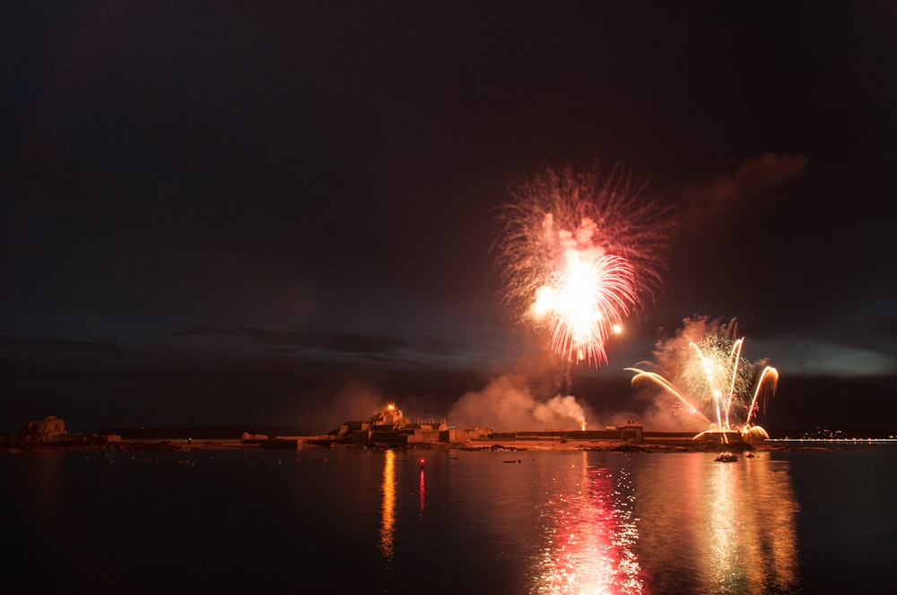 a firework display over a body of water at night