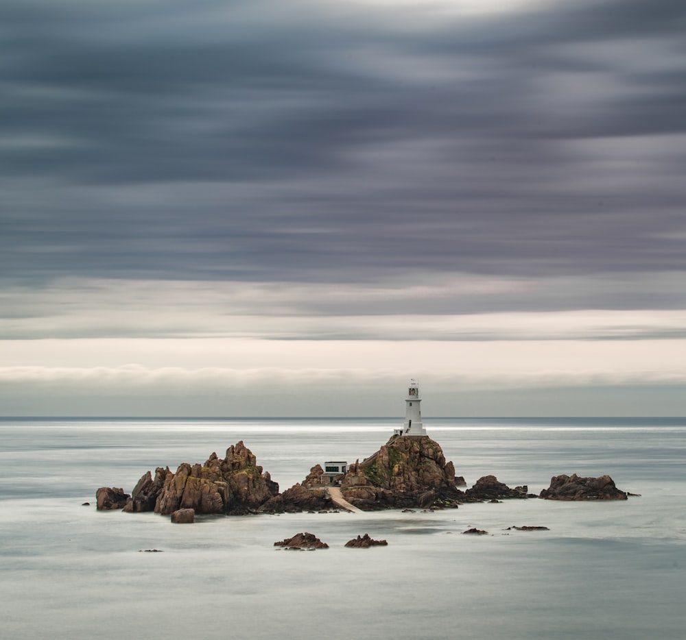 a lighthouse on a small island in the middle of the ocean