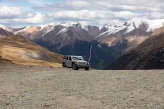 Snow-capped mountains in the Dolomites with a rugged SUV ready for an adventure.
