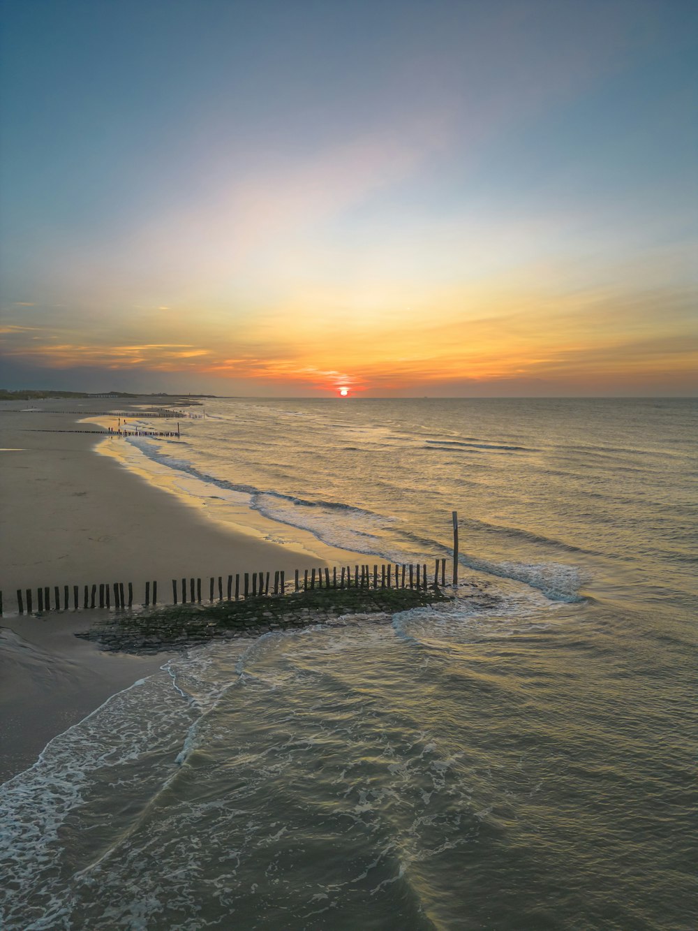 the sun is setting over the ocean and beach