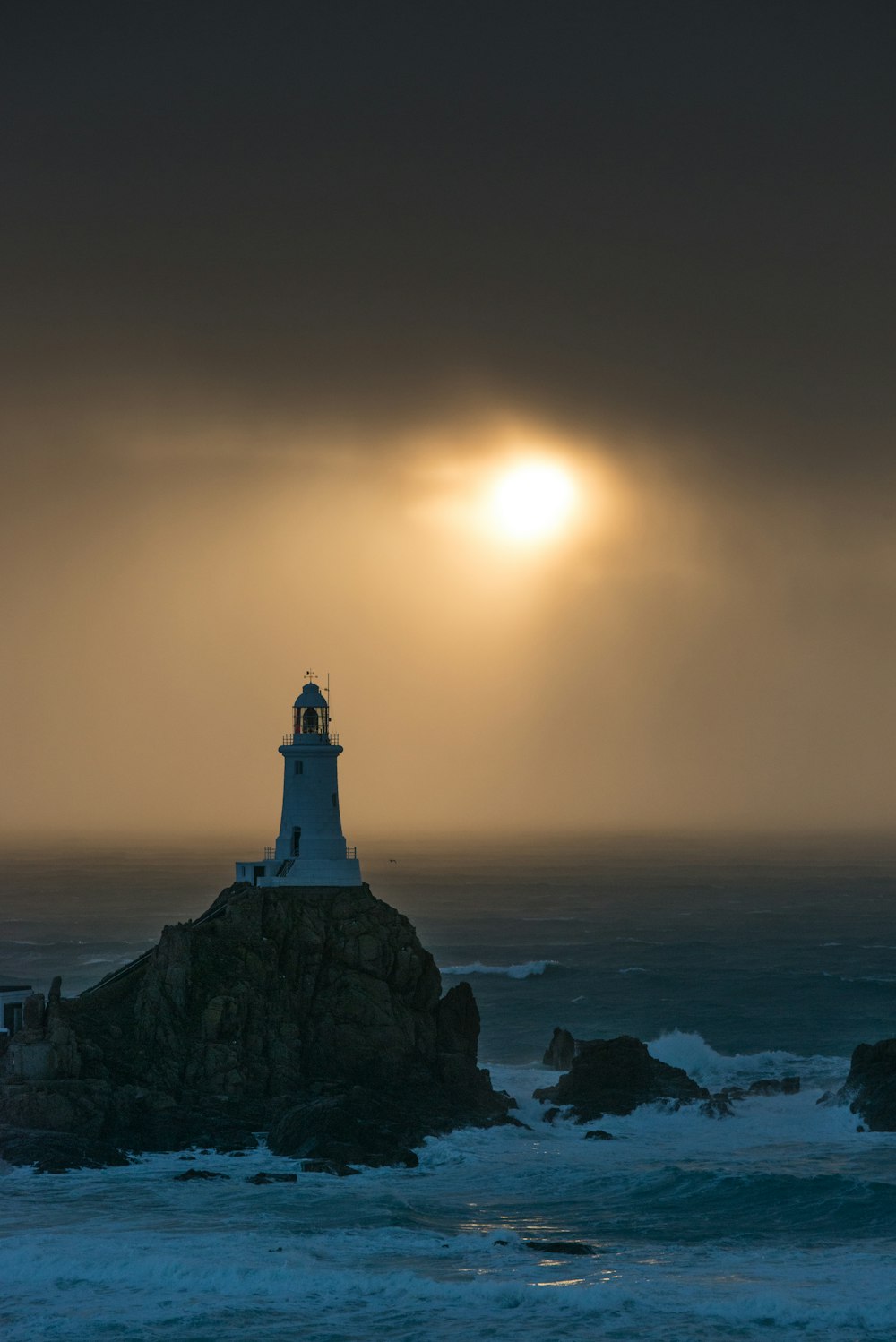Ein Leuchtturm, der auf einem Felsen in der Nähe des Ozeans sitzt