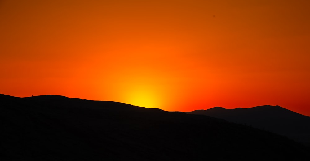 Le soleil se couche sur une chaîne de montagnes