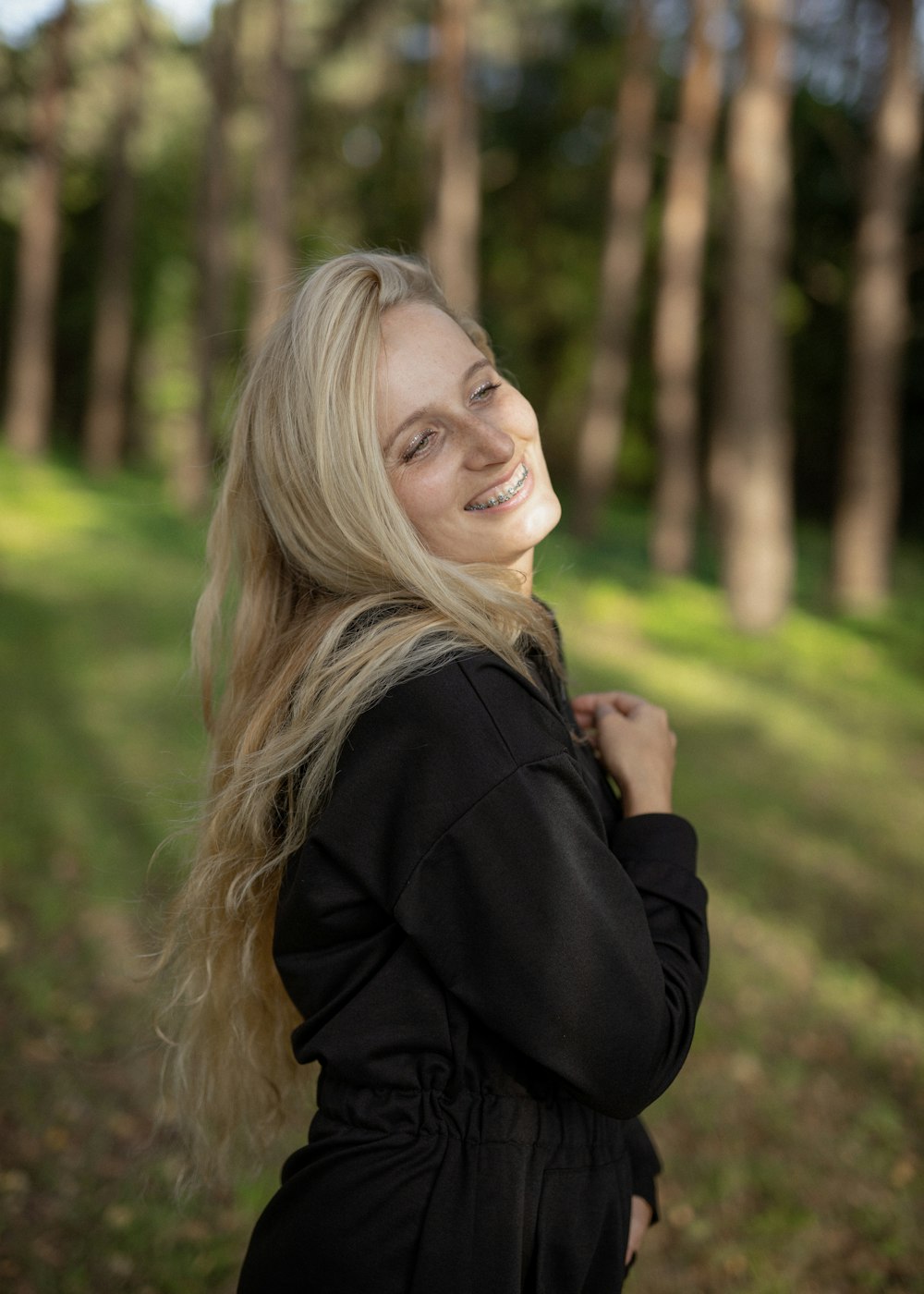 Una donna con lunghi capelli biondi che sorride alla macchina fotografica