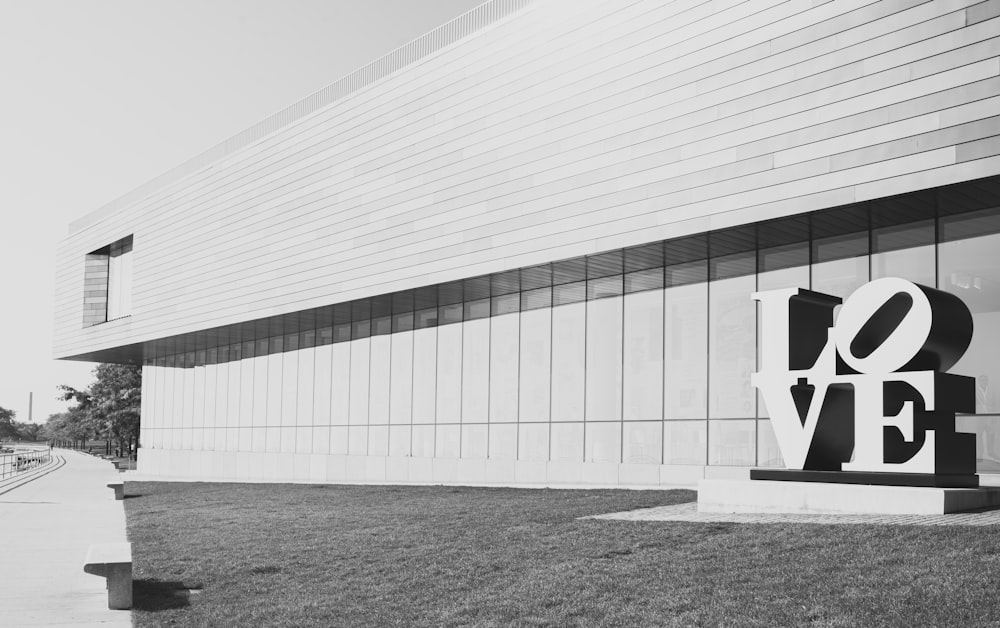 uma foto em preto e branco de um sinal de amor em frente a um prédio