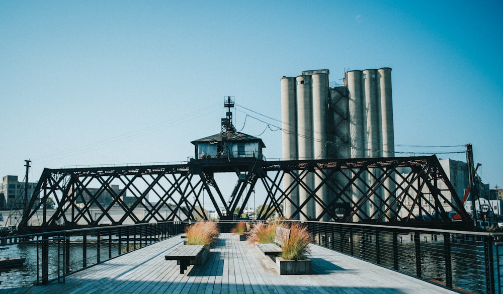 a pier with benches and a building in the background