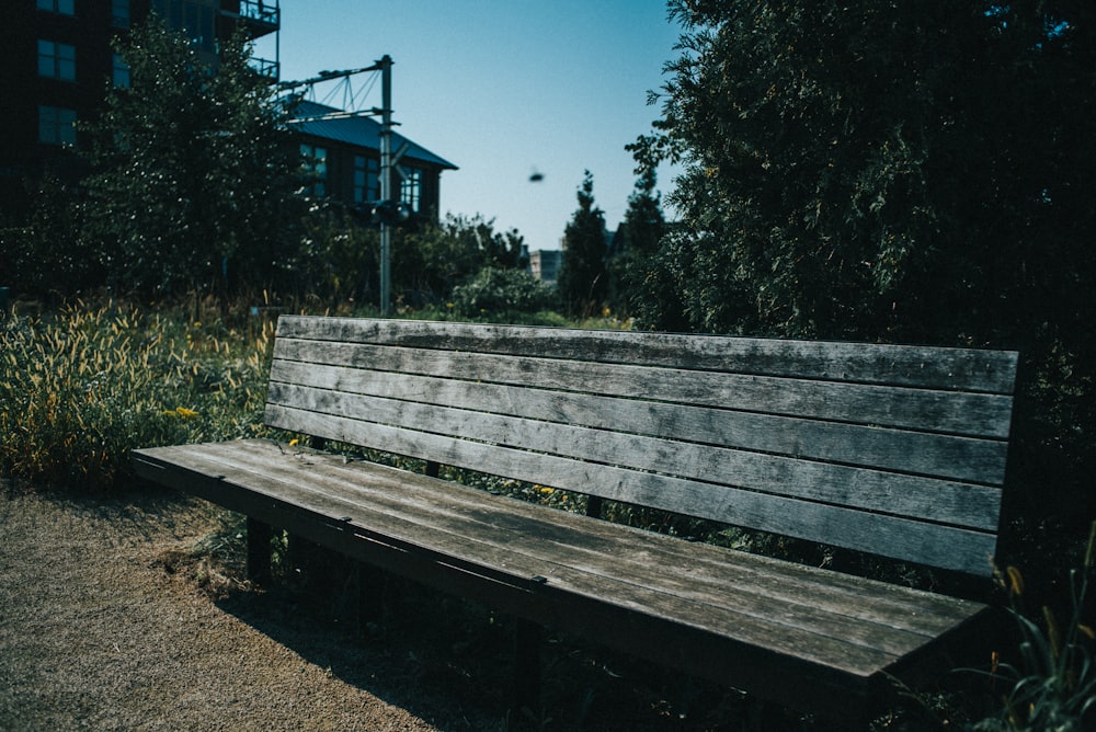 a wooden bench sitting next to a tall building