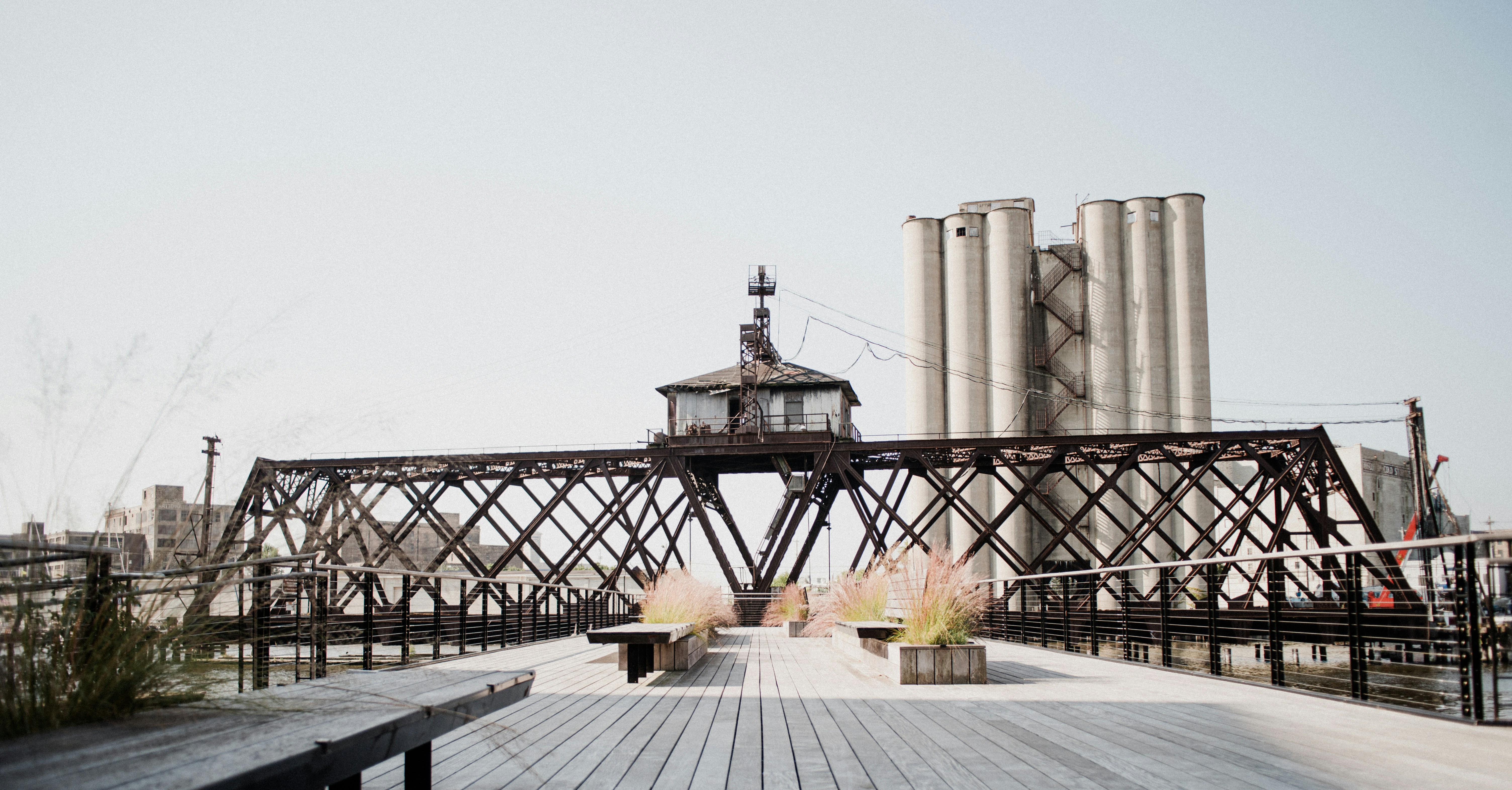 a wooden deck with benches and a light house on top of it