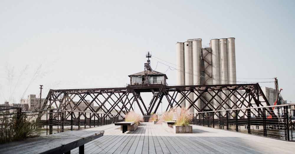 a wooden deck with benches and a light house on top of it