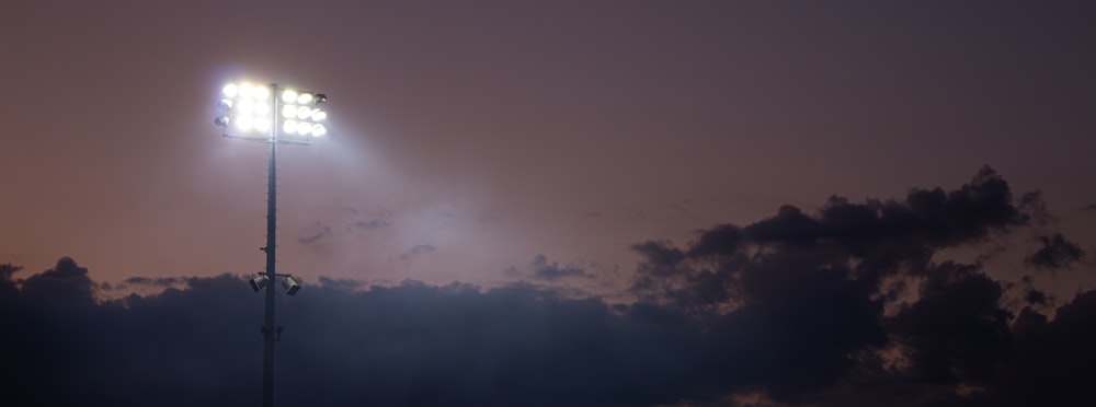 a street light with a cloudy sky in the background