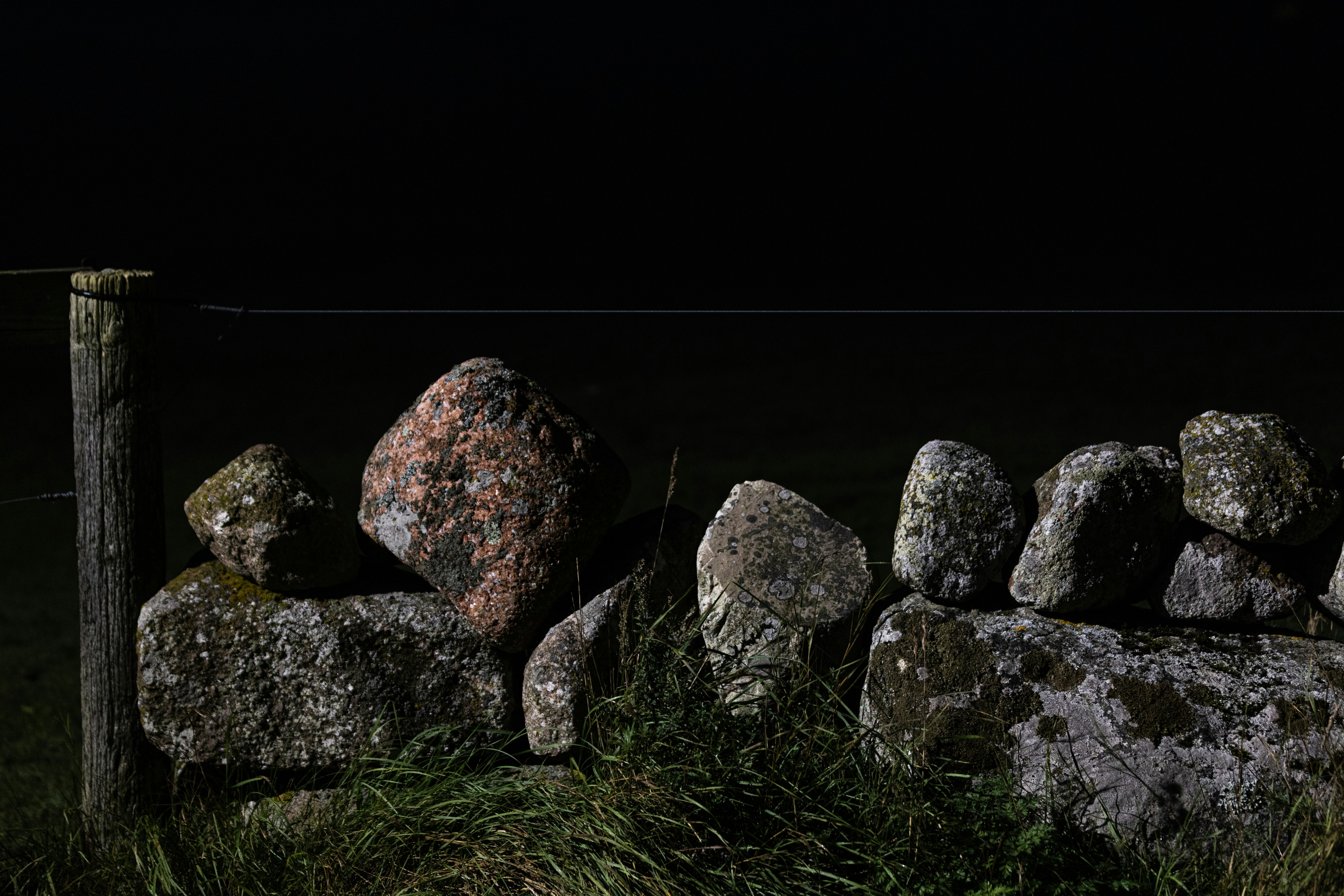 A row of loose rocks and stones in a field in the dead of might.