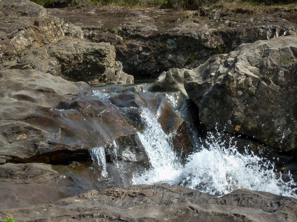 a stream of water running over rocks in a rocky area