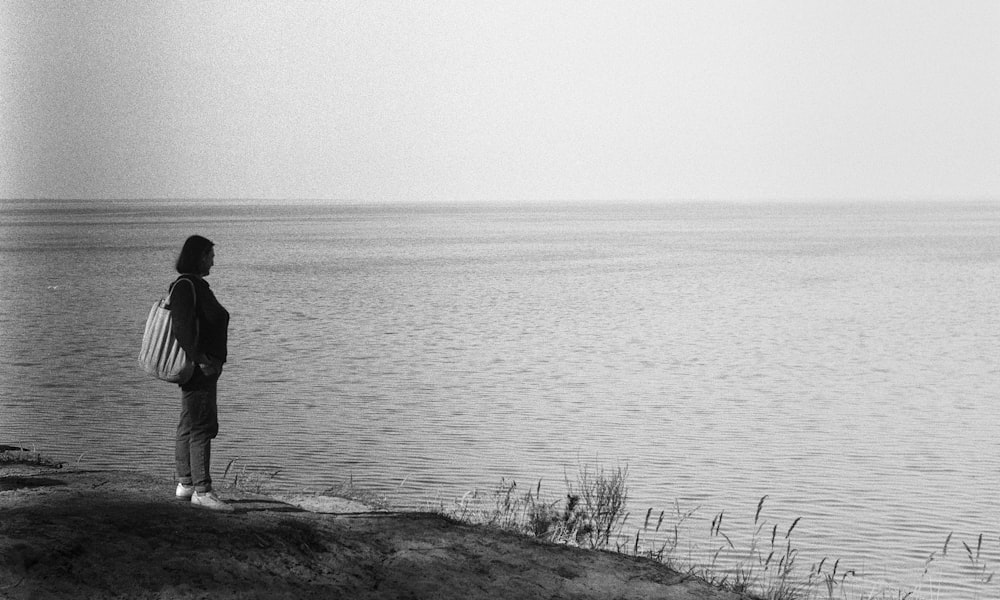 a person standing on a hill overlooking a body of water