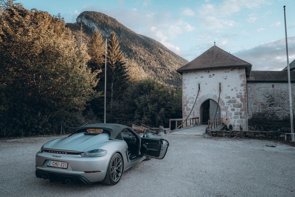 a silver sports car parked in front of a building