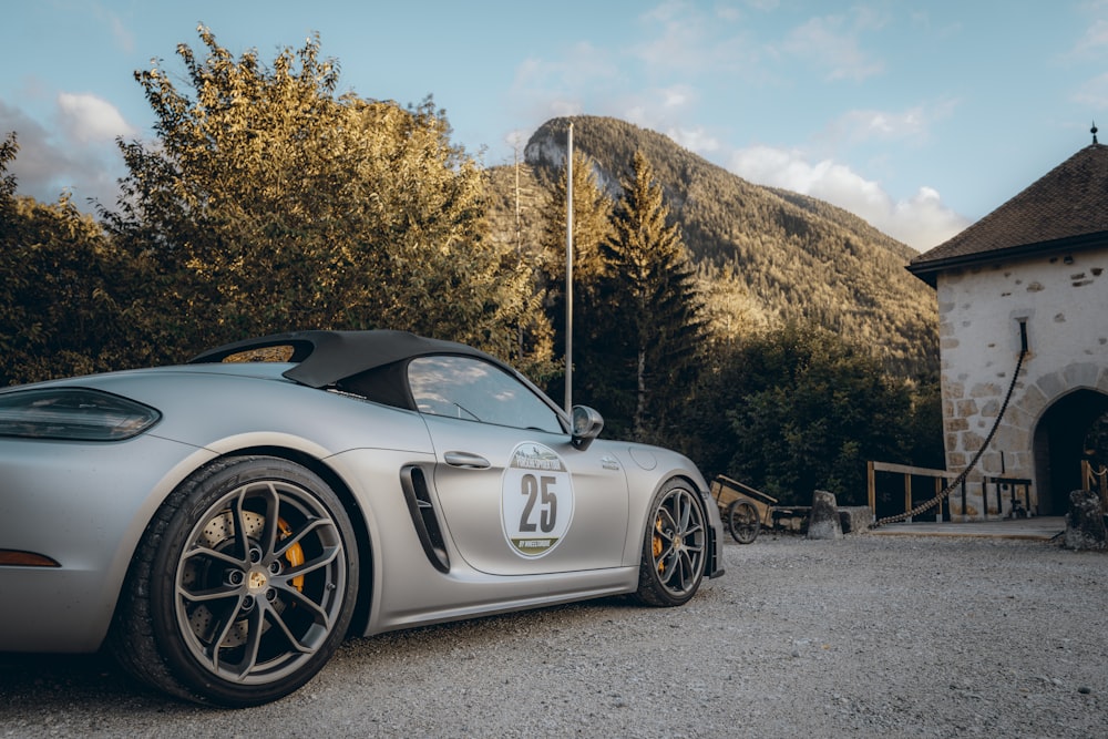 a silver sports car parked in front of a building