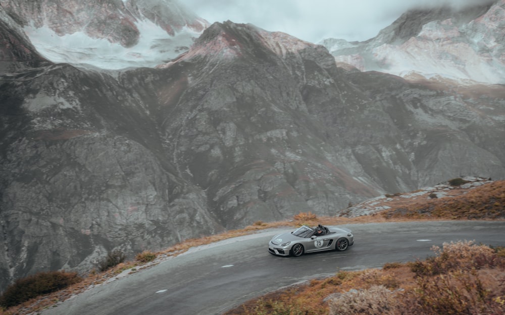 a sports car driving on a mountain road