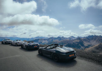 A panoramic view of a car event in Ticino, with cars lined up against a dramatic sky.