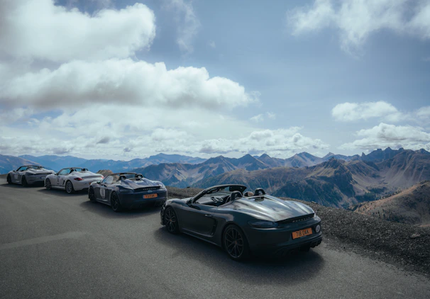 A panoramic view of a car event in Ticino, with cars lined up against a dramatic sky.