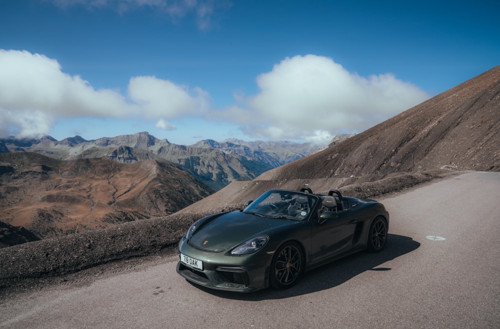 a black sports car parked on the side of a mountain road