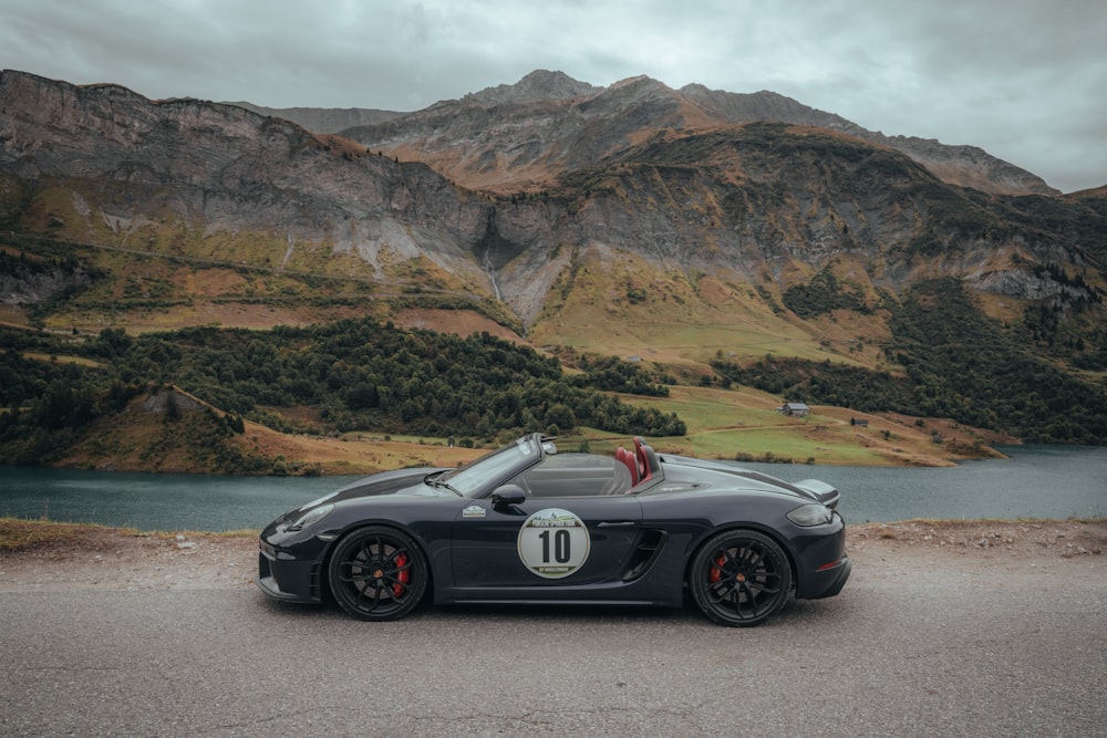 a black sports car parked in front of a mountain