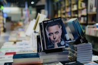 An author signing books at a local bookstore, smiling warmly.