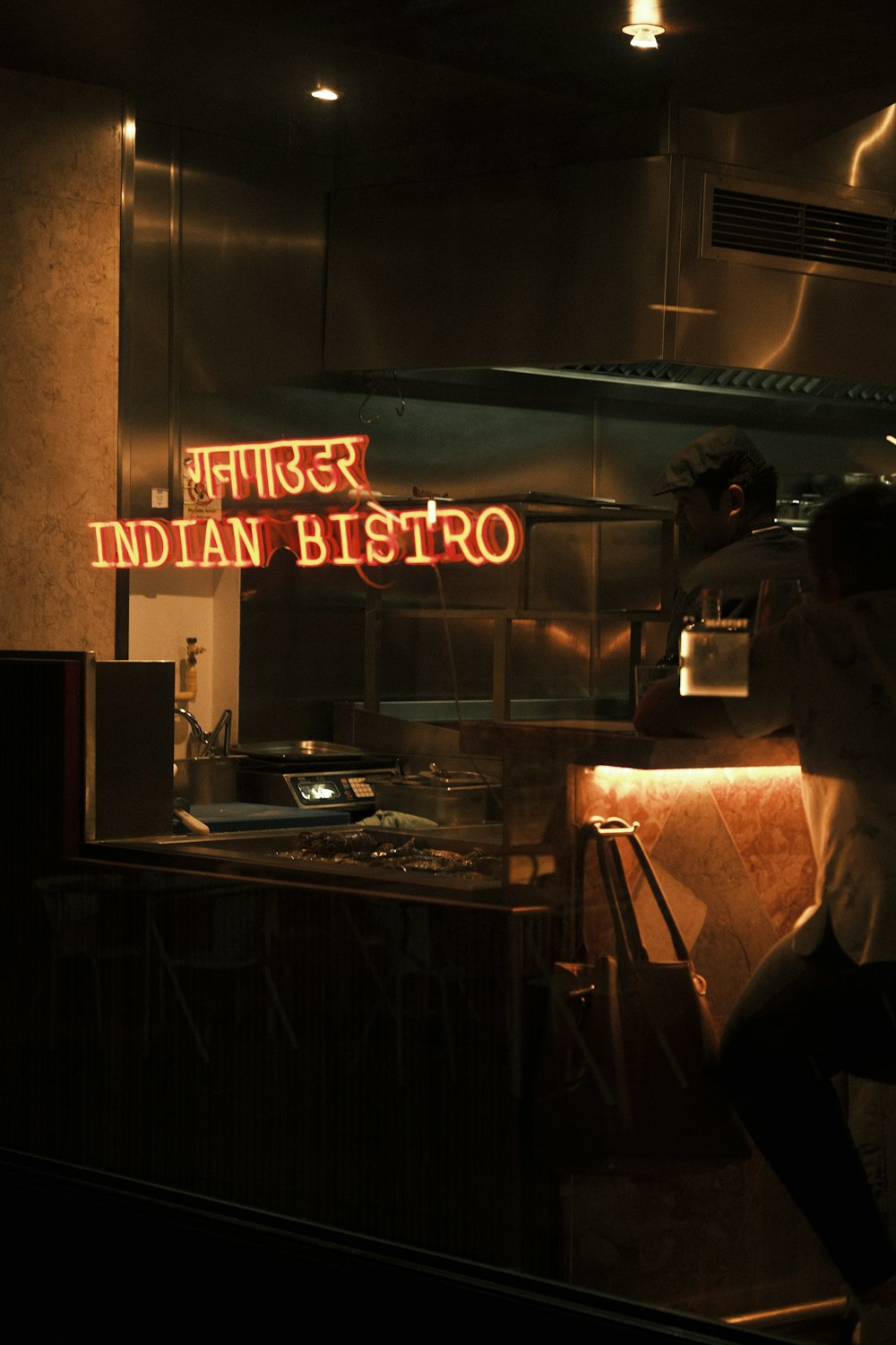 a man standing in a kitchen next to a neon sign