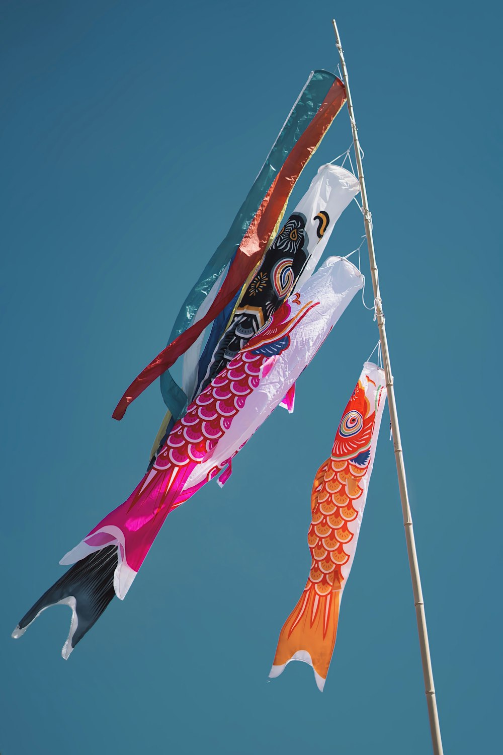 a kite flying in the sky with a fish on it