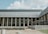 A modern building with tall columns supporting the structure, large glass windows, and a sleek facade. The sign on the building indicates it is the Tennessee State Library & Archives. The sky is partly cloudy, and there is a well-maintained landscape in front of the building.