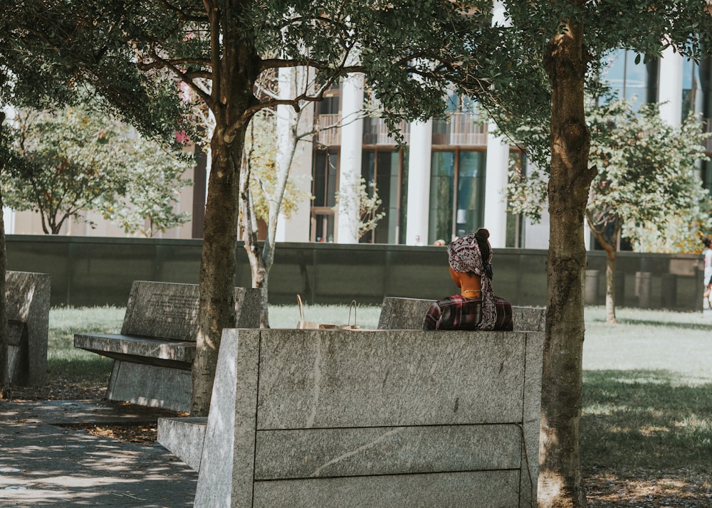 uma pessoa sentada em um banco em um parque