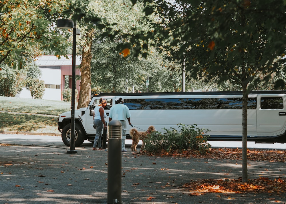 a group of people standing next to a white bus