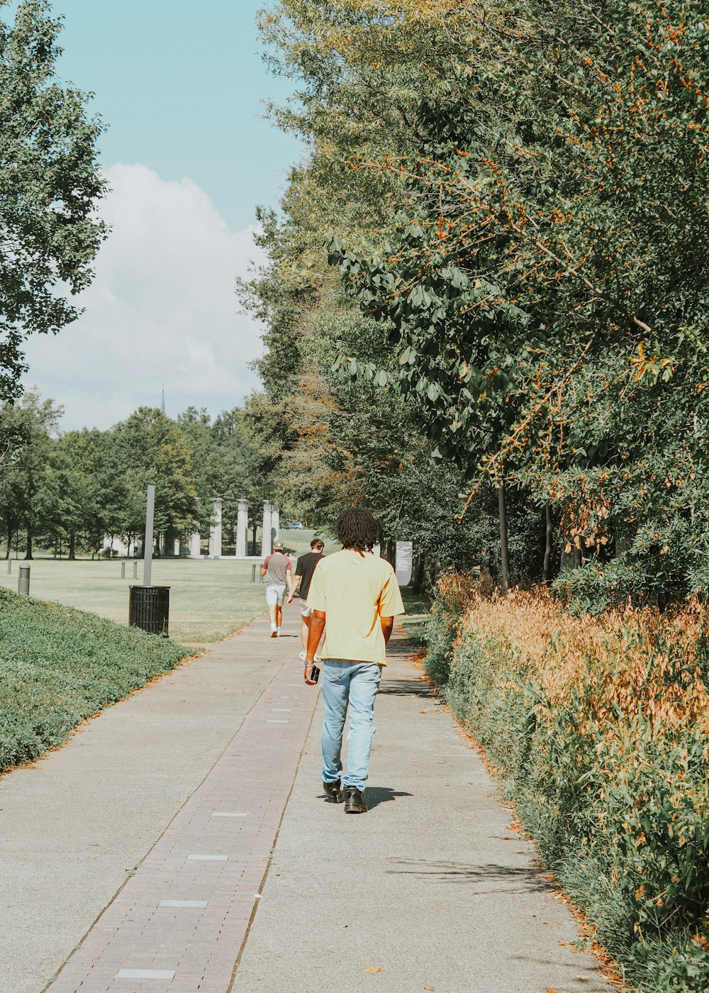 a man walking down a sidewalk in a park