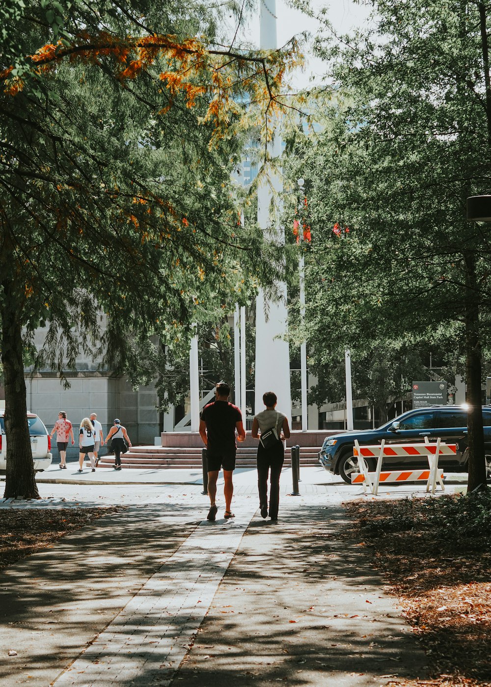 a couple of people walking down a sidewalk