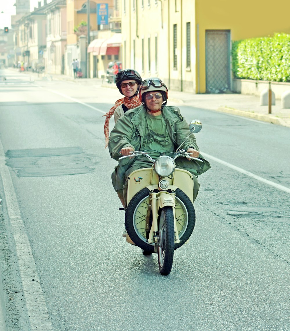 a man and a woman riding on the back of a motorcycle