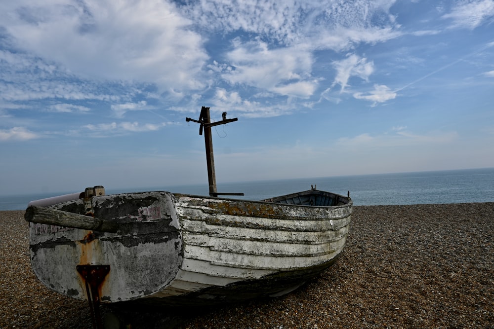 a boat on a beach with a cross on top of it