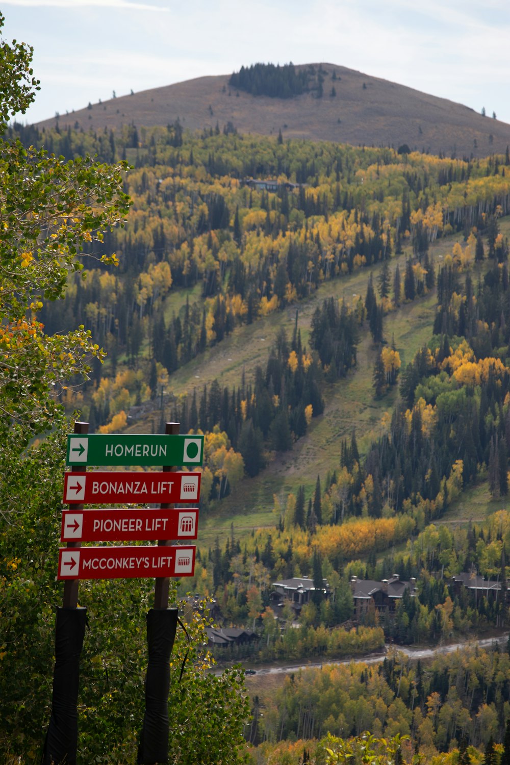 a sign on a pole in front of a mountain