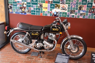 A vintage Norton motorcycle displayed in a classic museum setting with historical memorabilia.