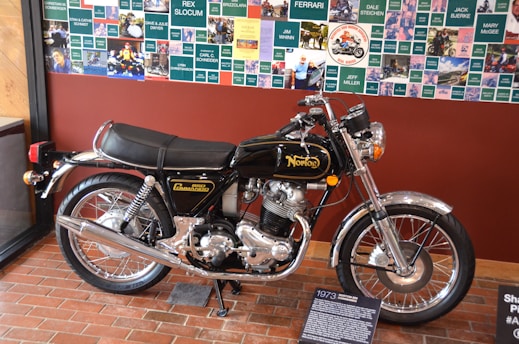A vintage Norton motorcycle displayed in a classic museum setting with historical memorabilia.