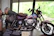 A carefully wrapped vintage motorcycle loaded onto a specialized carrier truck.